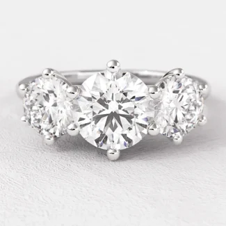 Vintage style 6 claw trilogy engagement ring on hand tr1058 from Bespoke Diamonds