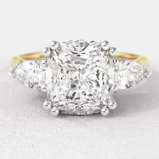 cushion cut and pear cut diamond trilogy engagement ring in yellow gold on hand tr1045 from Bespoke Diamonds