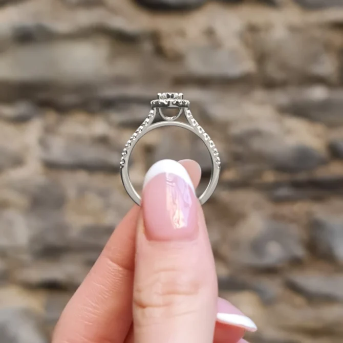 hand holding marquise halo engagement ring vr1051 in white gold