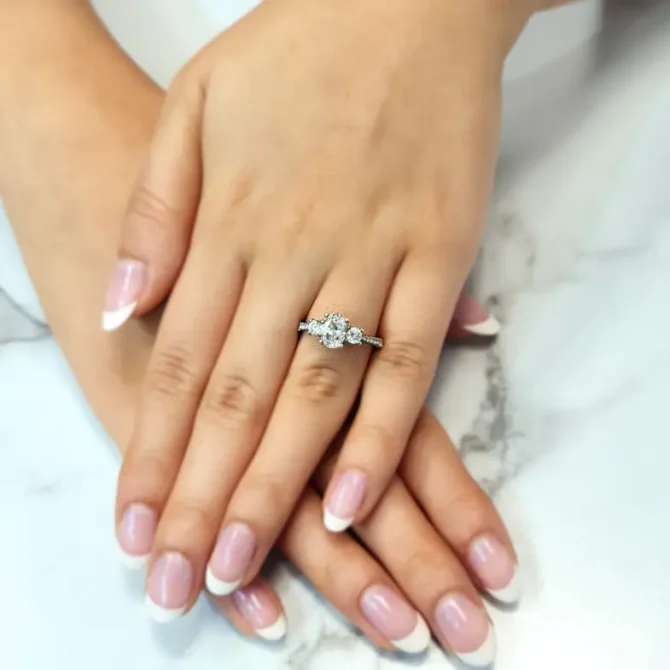 Oval trilogy engagement ring with diamonds on band on hand tr1056-4