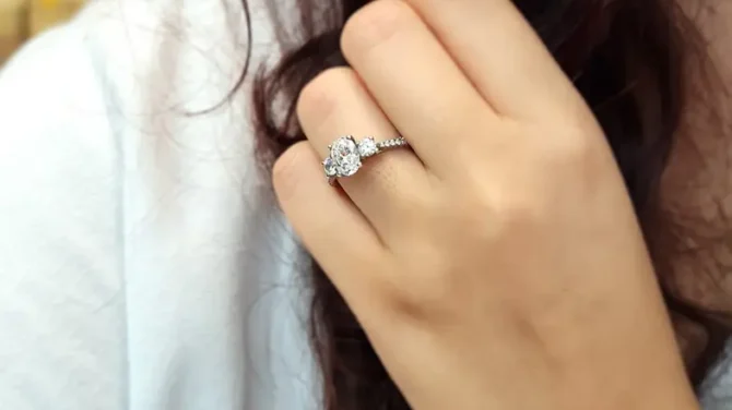 Oval trilogy engagement ring with diamonds on band on hand tr1056-3