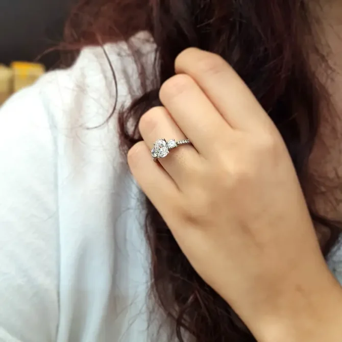 Oval trilogy engagement ring with diamonds on band on hand tr1056-3