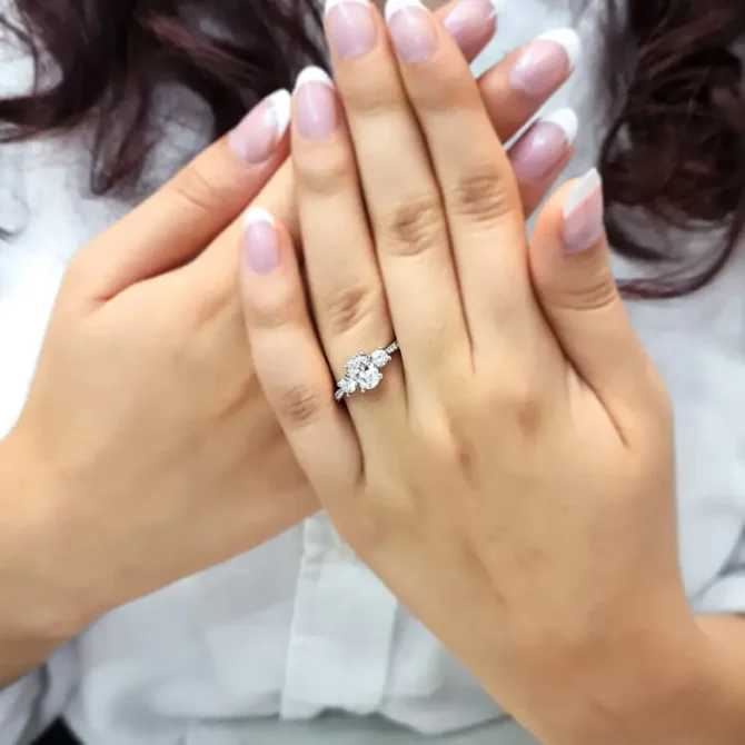 Oval trilogy engagement ring with diamonds on band on hand tr1056-2
