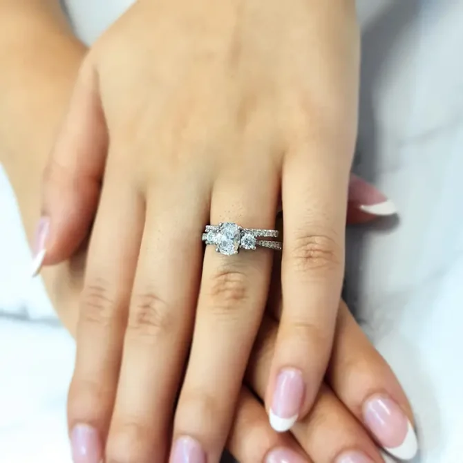 Oval trilogy engagement ring with diamonds on band on hand tr1056-1