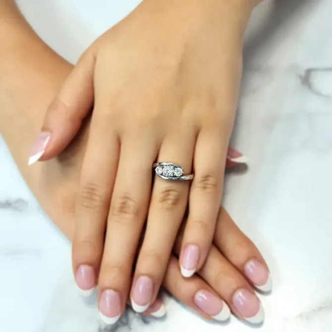 Twist three stone engagement ring on hand in white gold tr1002 made by Bespoke Diamonds in Dublin, Ireland