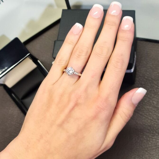 pr1009-round-cut-diamond-side-stone-engagement-ring-on-hand-image-1