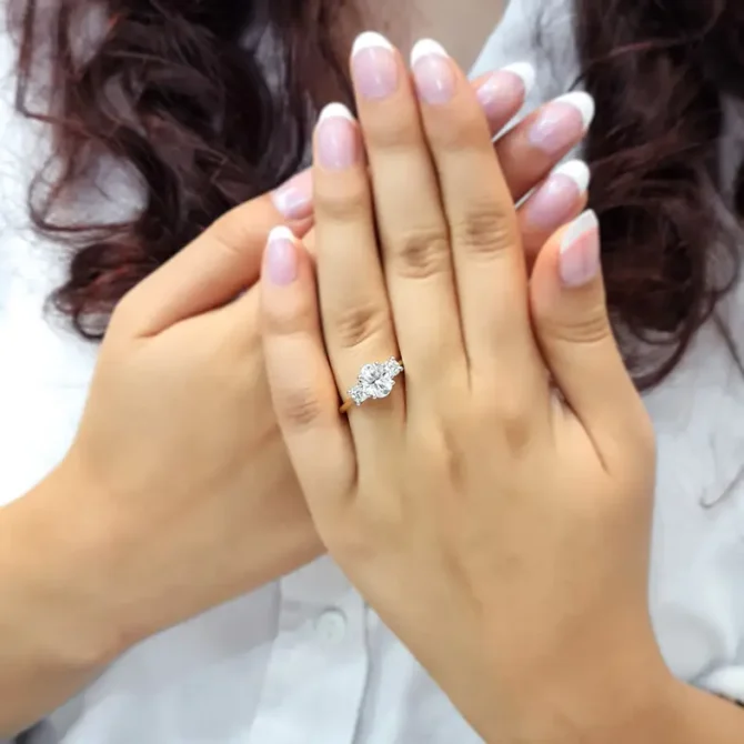 Yellow gold oval and round three stone diamond ring on hand-tr1028-3