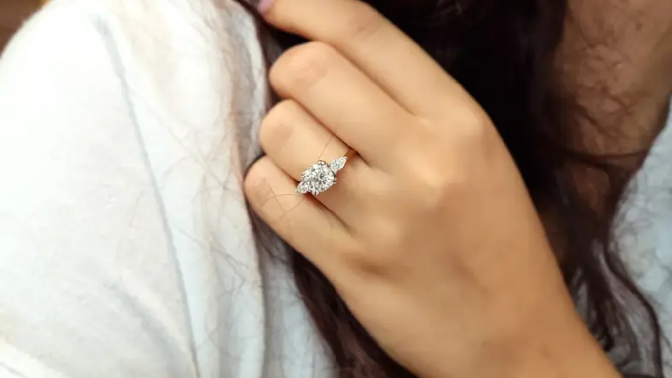 cushion cut and pear cut diamond trilogy engagement ring in yellow gold on hand tr1045 from Bespoke Diamonds, Ireland