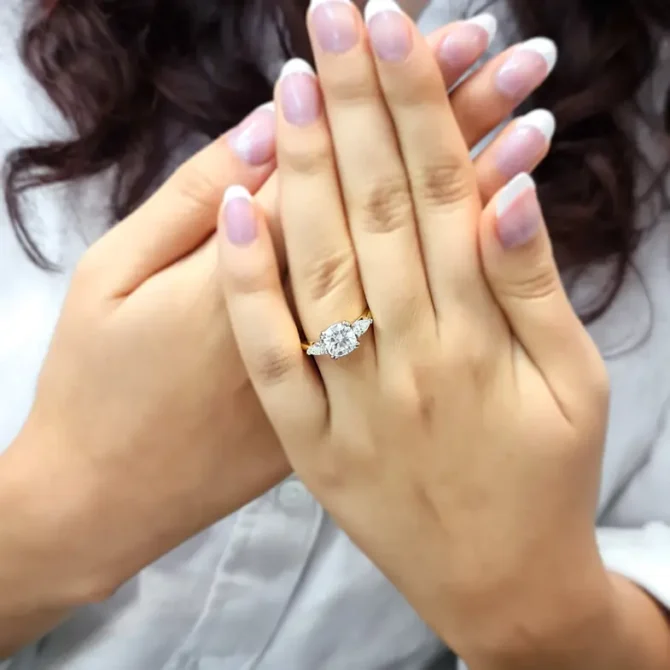 cushion cut and pear cut diamond trilogy engagement ring in yellow gold on hand tr1045 from Bespoke Diamonds, Ireland