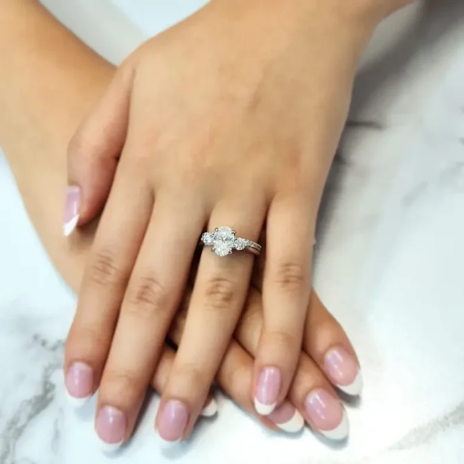 Oval three stone diamond ring on hand in white gold-tr1006-3