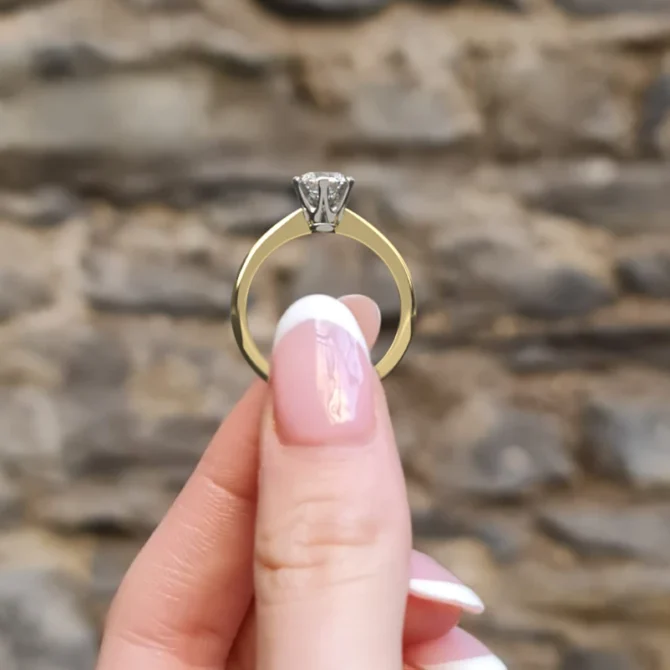 Tiffany style diamond engagement solitaire ring sr1055 in yellow gold side view in hand