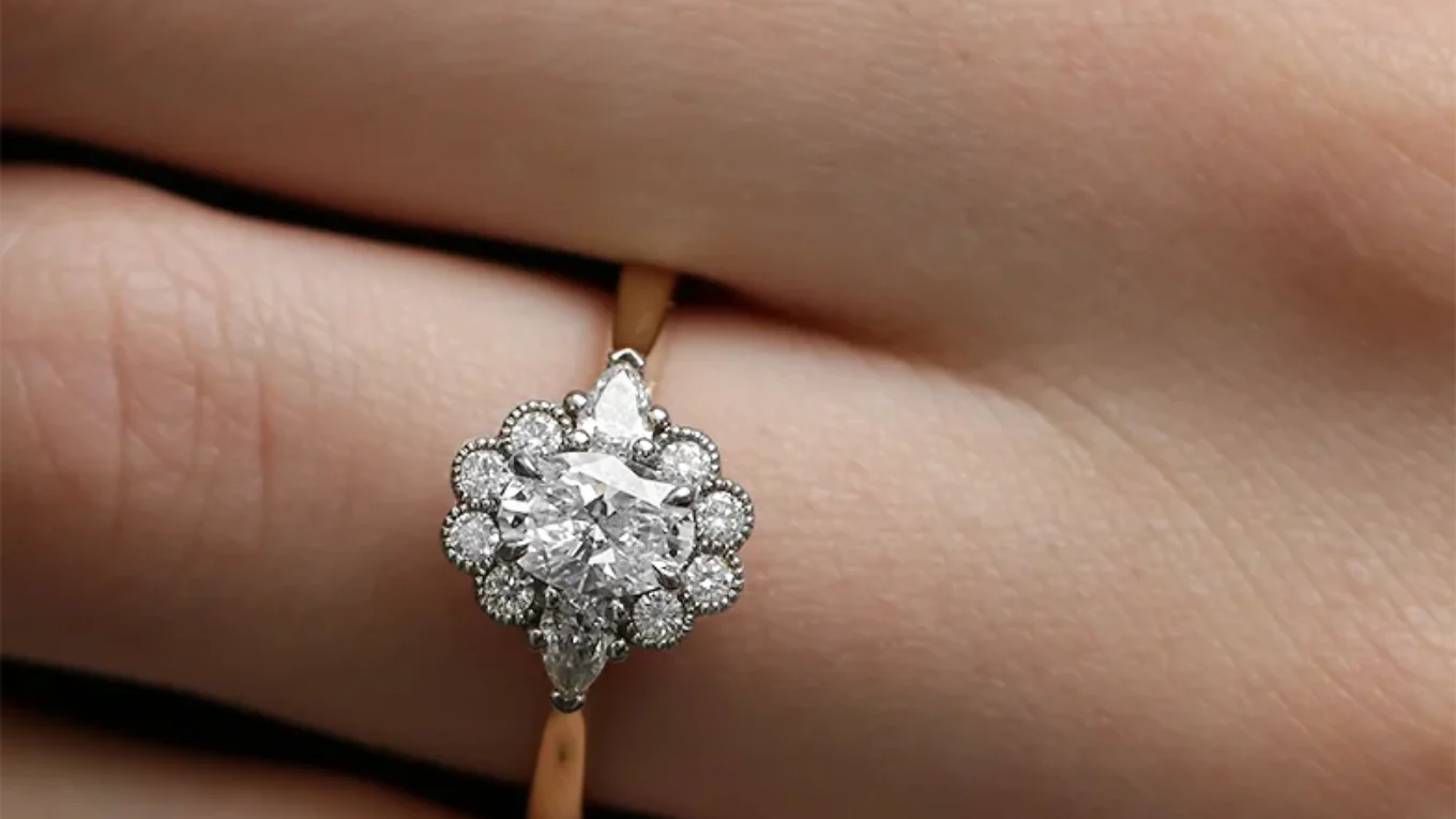 Vintage style oval halo and pear trilogy style engagement ring on hand vr1118