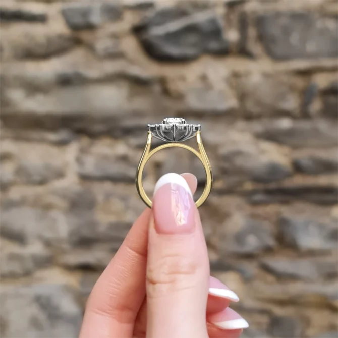 Oval Halo Trilogy Style Engagement Ring VR1100 in yellow gold side view in hand