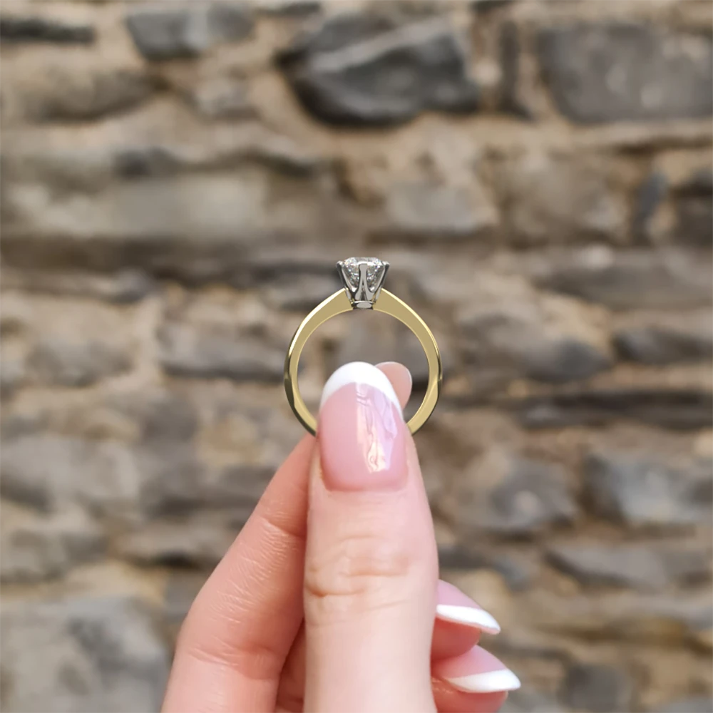 Tiffany style diamond engagement solitaire ring sr1055 in yellow gold side view in hand